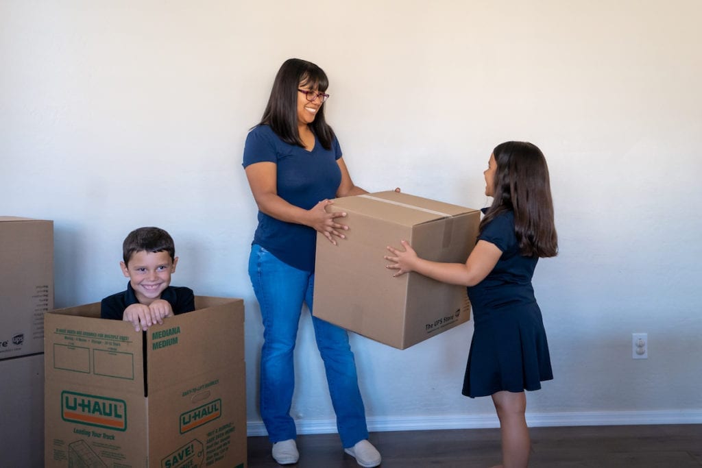 a person and two children in a room with boxes